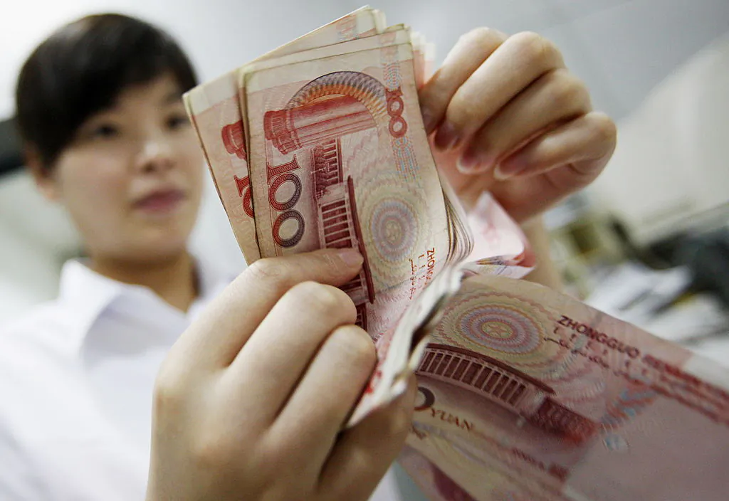 A Chinese bank worker counts stacks of 100 yuan (14.75 USD) notes at a bank in Huaibei, in eastern China's Anhui province on Aug. 4, 2010.   (STR/AFP/Getty Images)