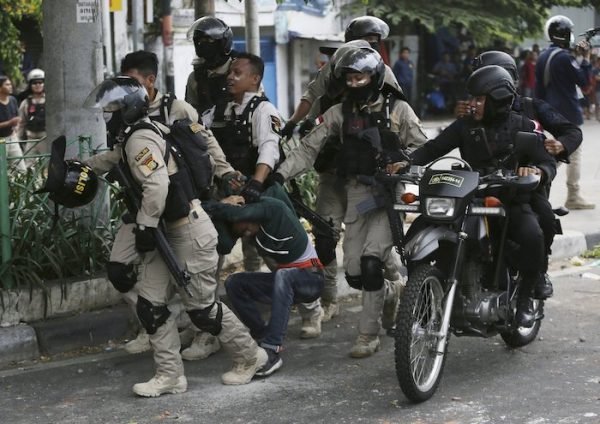 Indonesian police arrest a supporter of the losing presidential candidate in Jakarta