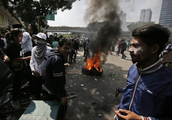 Protesters rest near burning tires