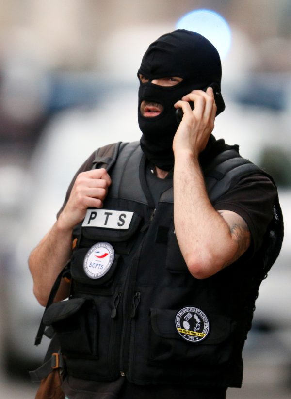 Police officer is seen on his mobile phone near the site of a suspected bomb attack in central Lyon