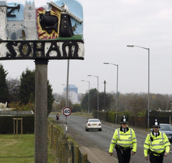 officers walking past Soham sign