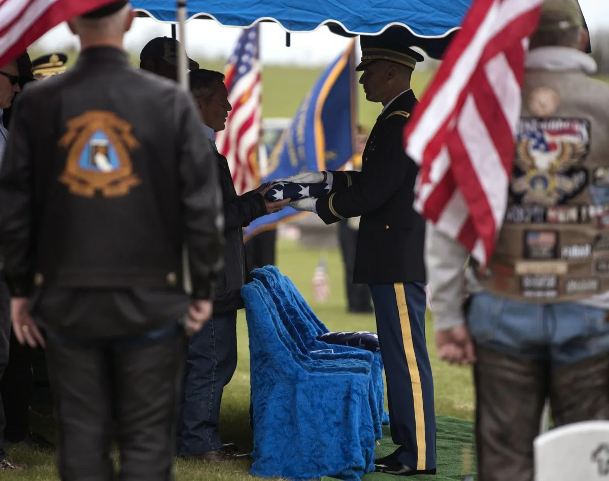 The honor guard presents Don McHenry, Pvt. William A. Boegli's eldest nephew, with a folded flag at Sunset Hills Cemetery in Bozeman, Mont., on May 25, 2019. (Rachel Leathe/Bozeman Daily Chronicle via AP)