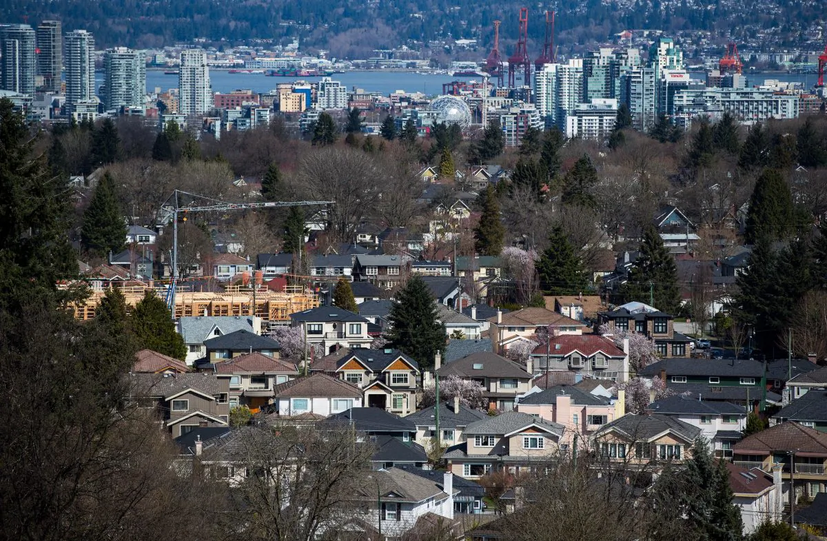 A condo building is seen under construction surrounded by houses with condo towers in the distance in Vancouver. The federal mortgage stress test has had a cooling effect on the housing market and industry groups want it modified. (The Canadian Press/Darryl Dyck)