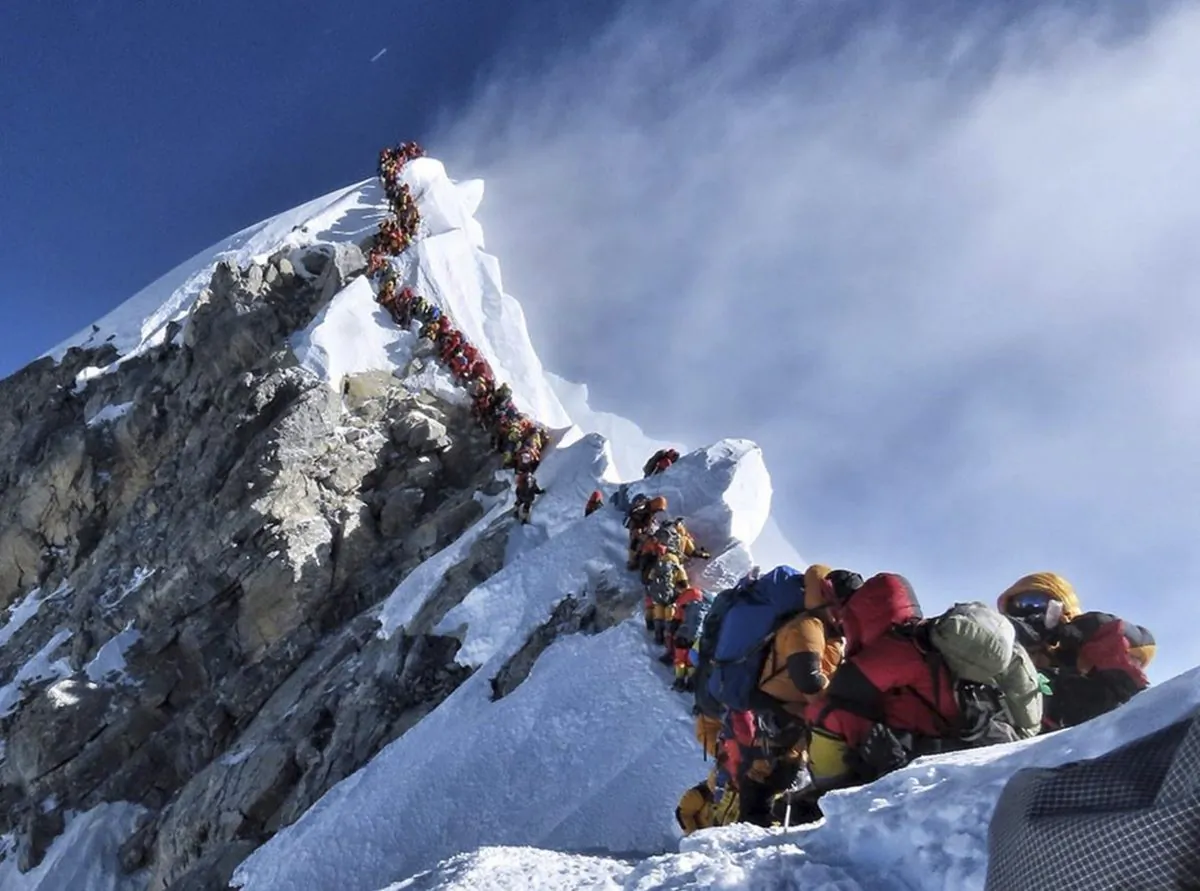 In this photo made on May 22, 2019, a long queue of mountain climbers line a path on Mount Everest. About half a dozen climbers died on Everest last week most while descending from the congested summit during only a few windows of good weather each May. (Nirmal Purja/@Nimsdai Project Possible/The Canadian Press)