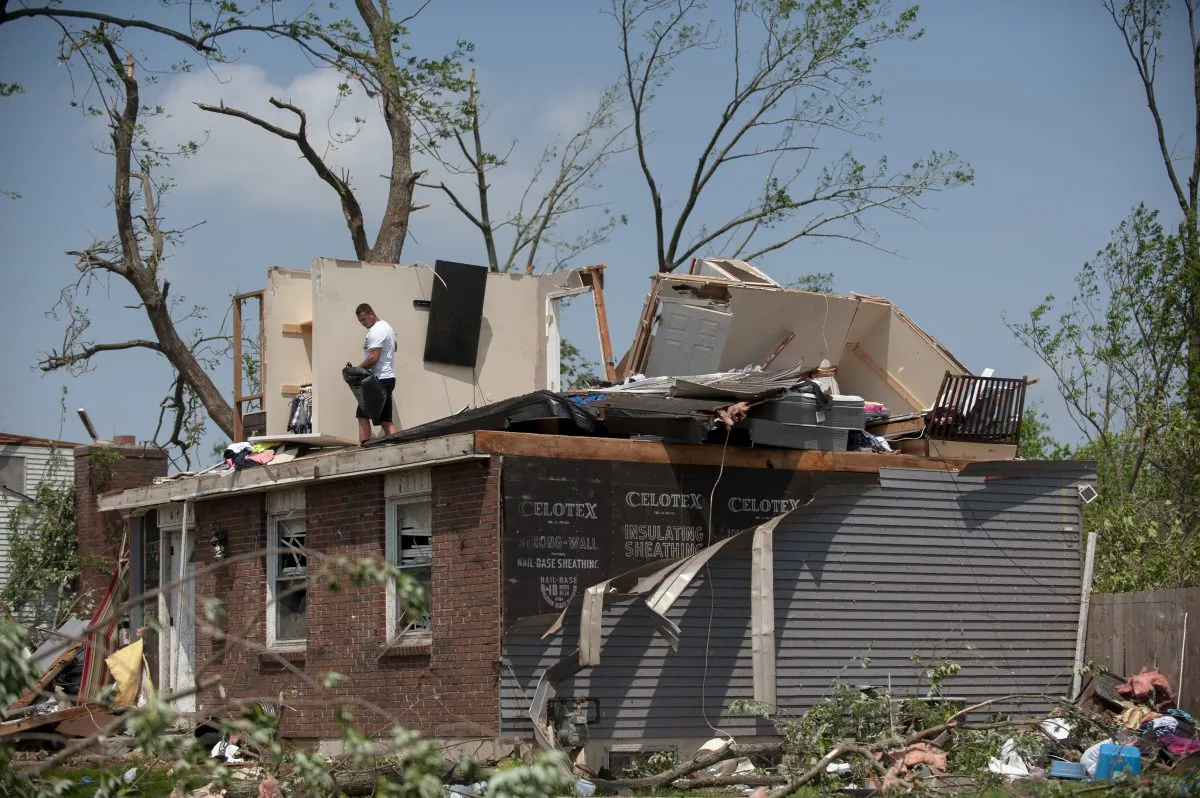 Residents in the West Brook neighborhood cut tree limbs and pick up scattered debris the morning after a suspected ef-4 tornado touched down early in Trotwood, Ohio, on the morning of May 28, 2019. (Matthew Hatcher/Getty Images)
