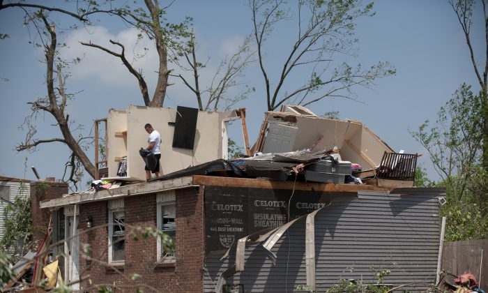 Residents in the West Brook neighborhood cut tree limbs and pick up scattered debris the morning after a suspected ef-4 tornado touched down early in Trotwood, Ohio, on the morning of May 28, 2019. (Matthew Hatcher/Getty Images)