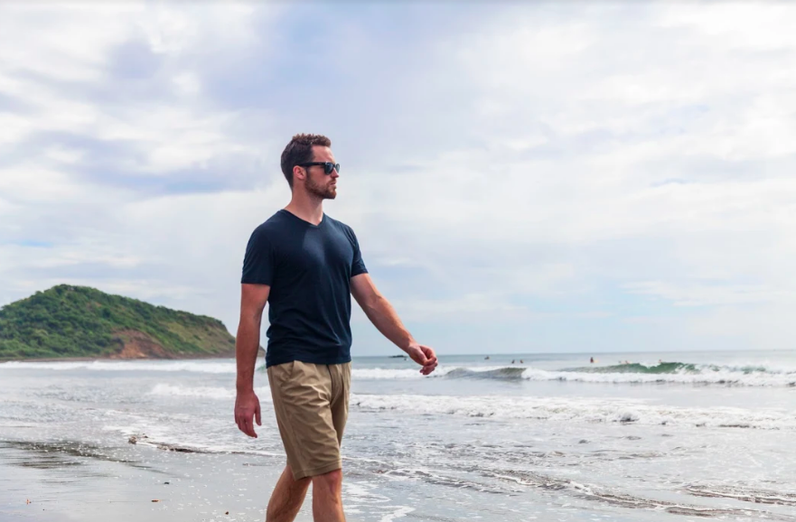 man walking on beach with wool shirt