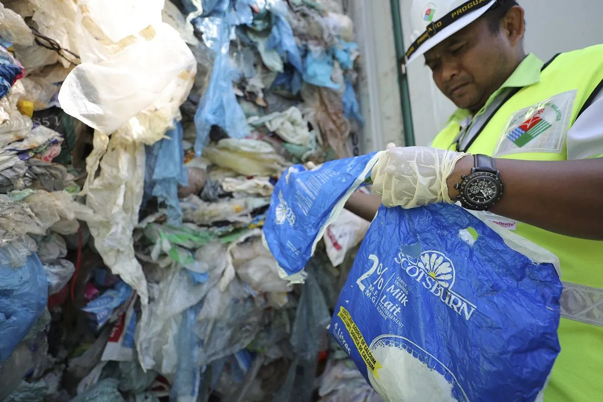 Officers from the Ministry of Environment examine a container full of non-recyclable plastic which was detained by authorities at the west port in Klang, Malaysia, on May 28, 2019. (Vincent /AP Photo)