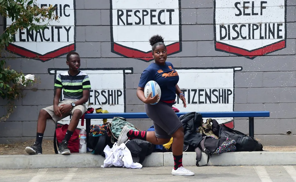 Students from View Park Preparatory Accelerated Charter High School play a game of rugby on the parking lot field on campus in Los Angeles, Calif., on Sept. 11, 2015. (Frederic J. Brown/AFP/Getty Images)