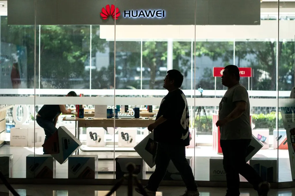 People walk past a Huawei retail store in Beijing on May 23, 2019. (Fred Dufour/AFP/Getty Images)