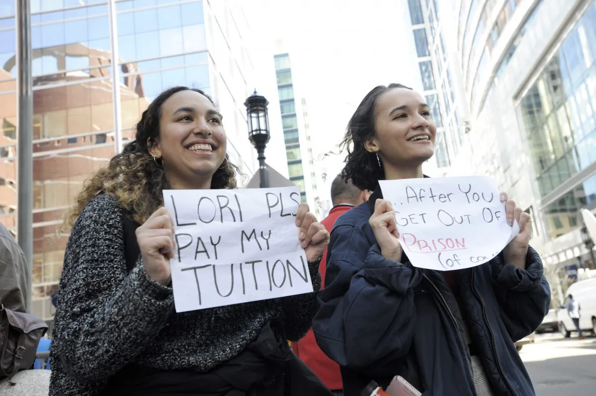 Mackenzie Thomas and Vivi Bonomie hold signs while actress Lori Loughlin faces charges for allegedly conspiring to commit mail fraud and other charges in the college admissions scandal at the John Joseph Moakley United States Courthouse in Boston on April 3, 2019. JOSEPH PREZIOSO/AFP/Getty Images)