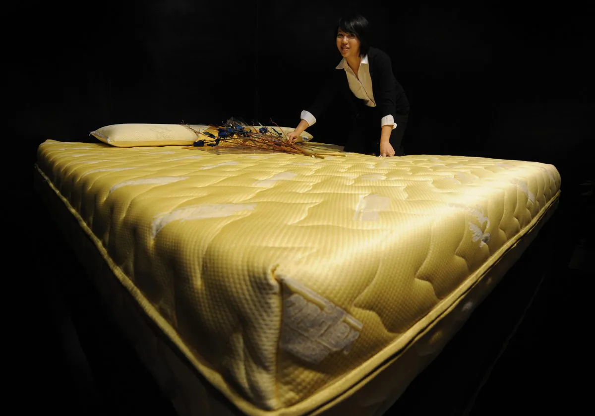 A sales representative shows a $24,000 22-carat gold thread mattress and matching $1,000 22-carat gold thread pillows made by the Italian firm Magniflex at a luxury goods fair in Shanghai, China on Oct. 10, 2008. (Mark Ralston/AFP/Getty Images)