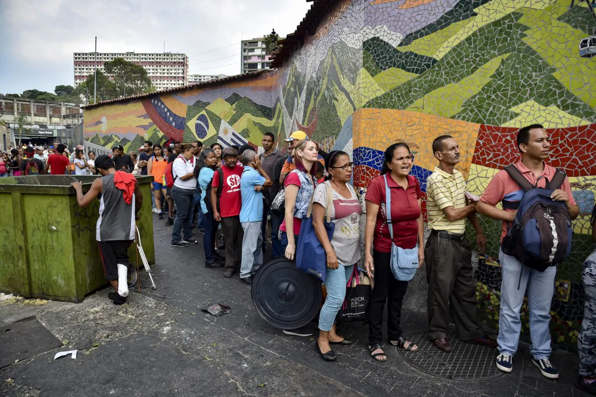 People stand in line to receive drums to collect water and water purification tablets from members of the Venezuelan Red Cross in Caracas, Venezuela, on April 16, 2019. (Yuri Corteza/AFP/Getty Images)