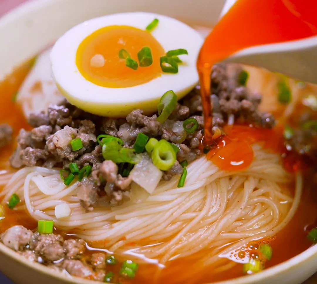 Rice noodle soup with beef and chili oil.