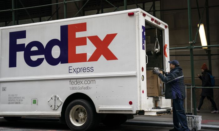 2018 年 12 月 19 日，一名联邦快递工作人员在纽约市金融区的卡车上卸下包裹。（Drew Angerer/Getty Images）