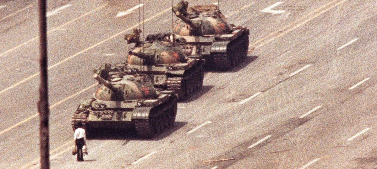 A man stands in front of a column of tanks in the Avenue of Eternal Peace in Beijing on June 5, 1989. (Arthur Tsang/Reuters)