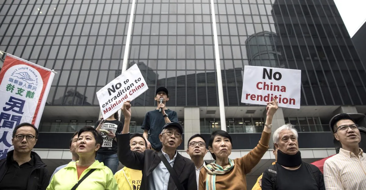 Hong Kong pro-democracy legislator Claudia Mo (centre R) and bookseller Lam Wing-kee (centre L) display placards outside the government headquarters during a rally in Hong Kong on March 31, 2019, to protest against the government's plans to approve extraditions with mainland China. (DALE DE LA REY/AFP/Getty Images)