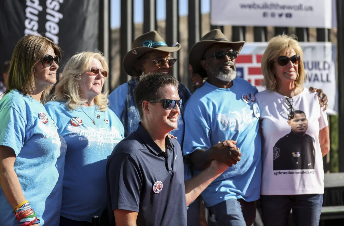 Brian Kolfage, founder of We Build the Wall, with a group of Angel parents, whose children have been killed by illegal aliens, in front of the new half-mile section of border fence at Sunland Park, N.M., on May 30, 2019. (Charlotte Cuthbertson/The Epoch Times)