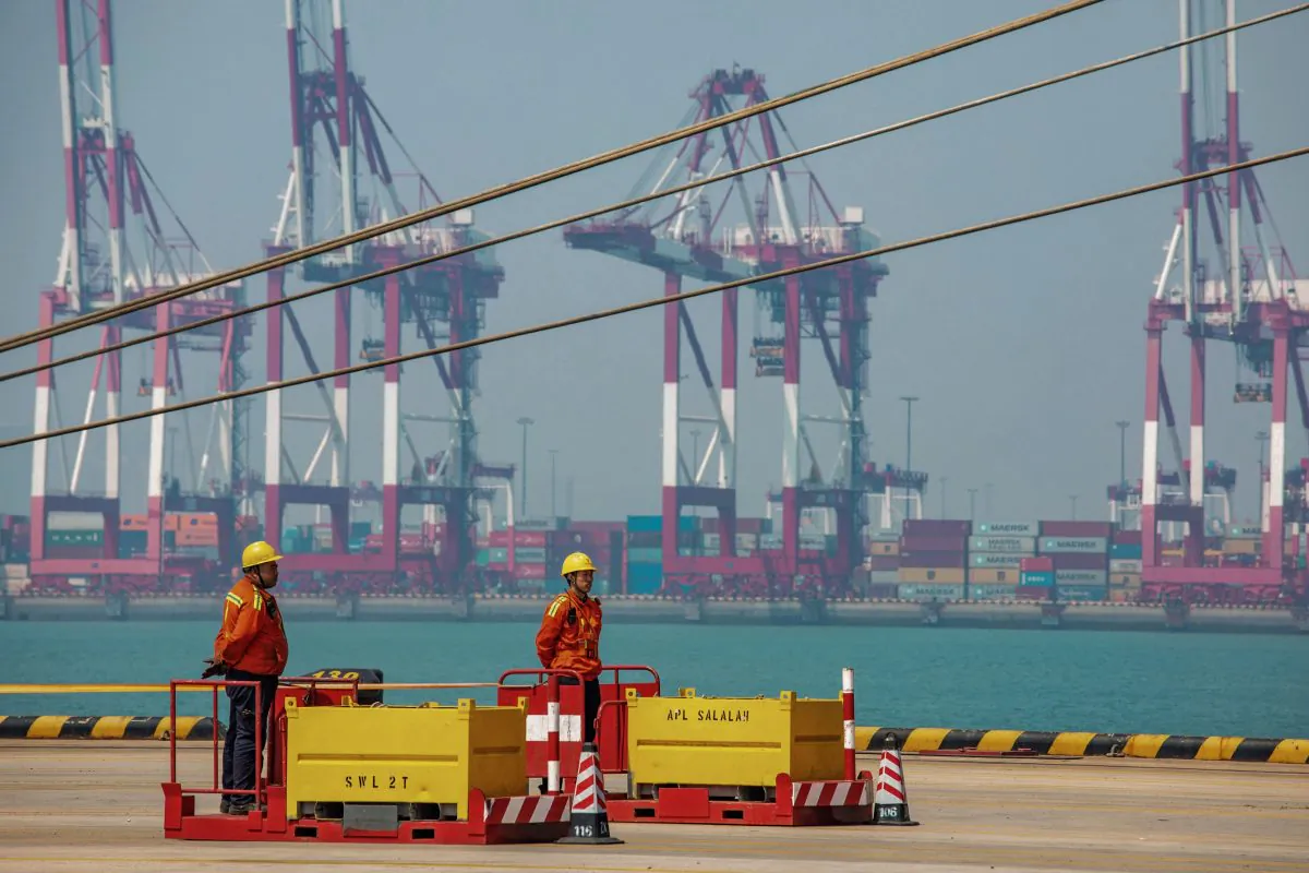 Two staff members stand at a port in Qingdao in China's eastern Shandong Province on April 17, 2019. (STR/AFP/Getty Images)
