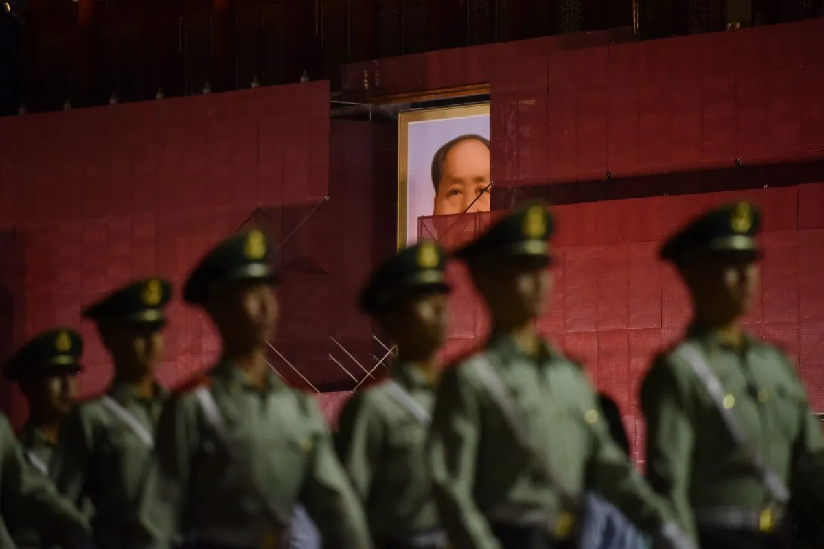 Paramilitary police officers marching past the portrait of late communist leader Mao Zedong on Tiananmen Gate, as it undergoes renovations in Beijing on May 18, 2019. (Greg Baker/AFP/Getty Images)
