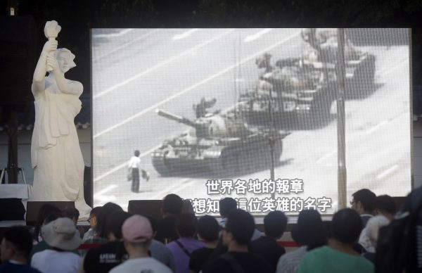People watch a giant screen as they attend the Tiananmen Anniversary at Democracy Square in Taipei, Taiwan, Tuesday, June 4, 2019, to mark the 30th anniversary of the Chinese military crackdown on the pro-democracy movement in Beijing's Tiananmen Square. (AP Photo/Chiang Ying-ying)