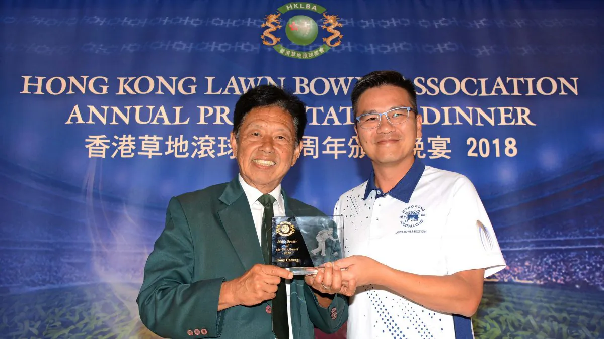 Tony Cheung (right) from Hong Kong Football Club receives his second Bowler of the Year trophy from Vincent Cheung, the President of the Hong Kong Lawn Bowls Association at the HKLBA annual presentation dinner last Friday, May 31. (Stephanie Worth)