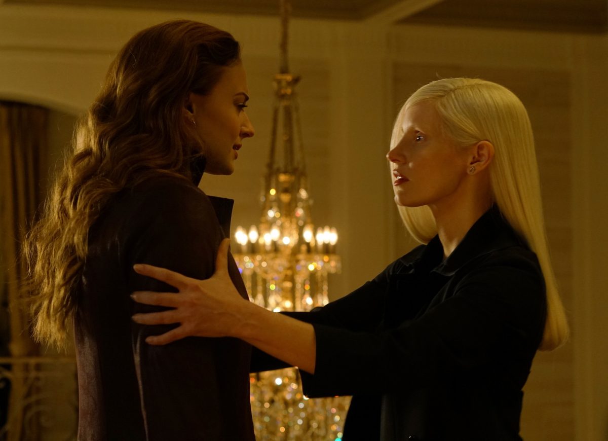 brunette and blonde women in front of chandelier