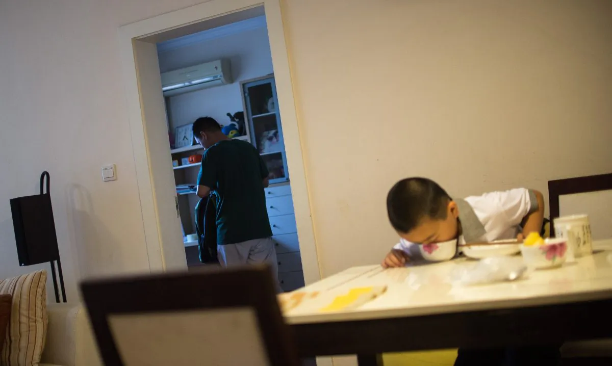 A boy eating with his father in the background. (Johannes Eisele/AFP/Getty Images)