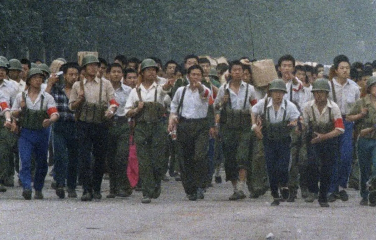 In this June 6, 1989, photo, Chinese soldiers marching away from Tiananmen point out an an Associated Press reporter taking photos, which was against the regulations of martial law that had been declared May 20 and later gave chase, firing twice before the reporter escaped near the International Hotel in Beijing. The Chinese army had fought its way into Tiananmen Square the night of June 3-4 to reclaim the square from student-led demonstrators who had been protesting for democratic reforms for three weeks. (Terril Jones/AP)