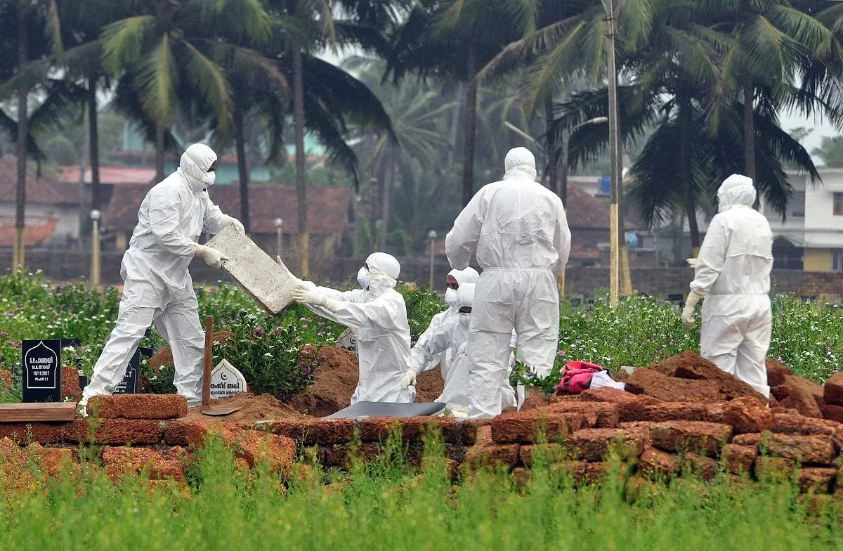 Doctors and relatives wearing protective gear dig a grave to bury the body of a Nipah virus victim on May 24, 2018.(Stringer/Reuters)