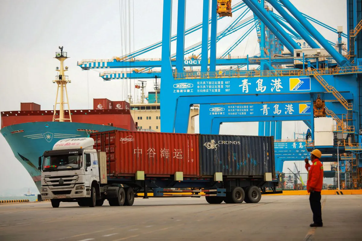 A staff member watches over a truck as he talks on his interphone at a port in Qingdao City, Shandong Province, China, on November 8, 2018. STR/AFP/Getty Images