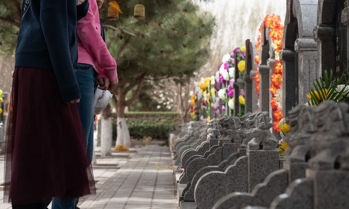 People standing in front of graves in China. (Fred Dufour/AFP/Getty Images)