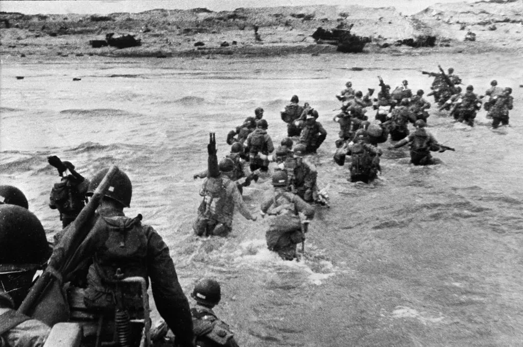 American troops landed on Normandy beaches (north-west of France), to come as reinforcements during the historic D-Day, June 6, 1944, during WW2. American troops supporting those already on the coast of Northern France, plunge into the surf and wade shoreward carrying equipment, on Utah Beach, Les Dunes de Madeleine, France. Bulldozers and other engineer equipment prepare the beach for the landing parties. (STF/AFP/Getty Images)