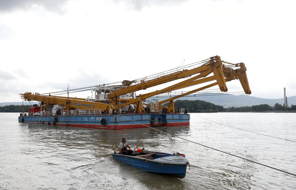 A floating crane able to lift 200 tons and which would be able to hoist the boat out of the water on its way on the site of the accident where a sightseeing boat capsized in Budapest, Hungary, Wednesday, on June 5, 2019. (AP Photo/Laszlo Balogh)