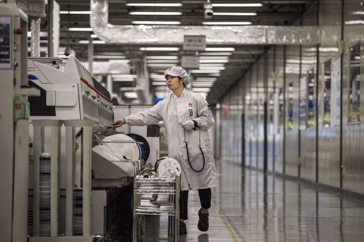 A worker packs up new smartphone devices at the end of the production line at Huawei's production campus on April 11, 2019 in Dongguan, near Shenzhen, China. (Kevin Frayer/Getty Images)