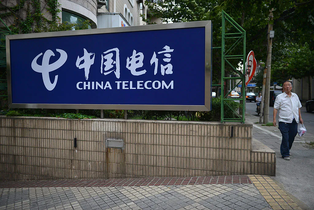 A pedestrian walks past a China Telecom sign on a street in Shanghai on Aug. 21, 2013. (PETER PARKS/AFP/Getty Images)