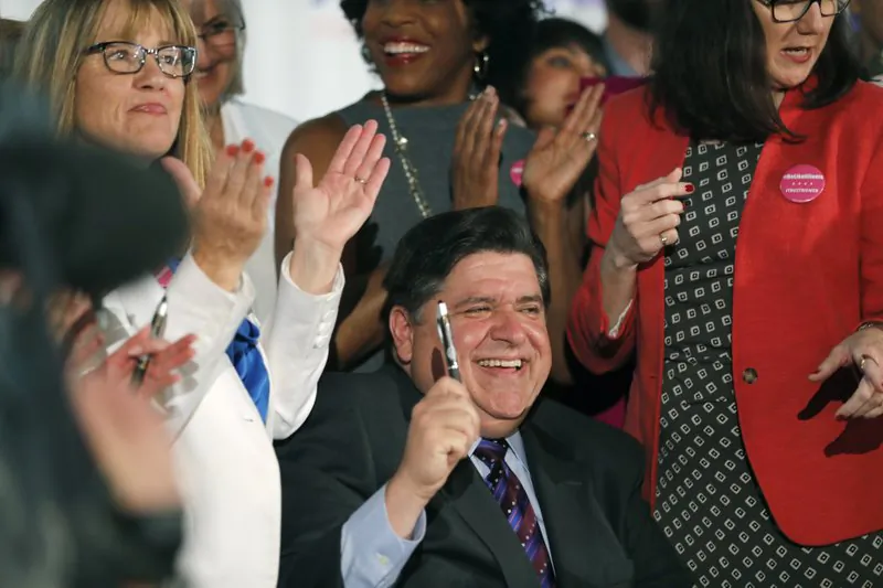 Illinois Gov. J.B. Pritzker signs the Reproductive Health Act into law with bill sponsors Illinois State Senator Melinda Bush, left, and Illinois State Rep. Kelly Cassidy, right, at the Chicago Cultural Center on June 12, 2019. (Jose M. Osorio/Chicago Tribune via AP)