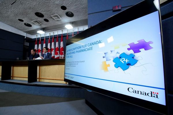 Dr. Eric Hoskins, Chair of the Advisory Council on the Implementation of National Pharmacare, is accompanied by Vincent Dumez, Member of the Advisory Council on the Implementation of National Pharmacare, during a press conference at the National Press Theatre in Ottawa on June 12, 2019. (Sean Kilpatrick/The Canadian Press)