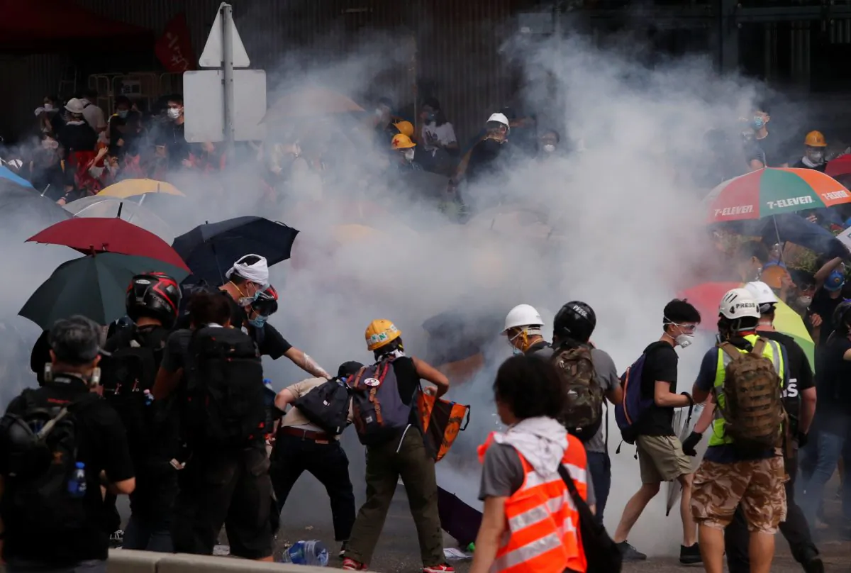 Protesters react to a tear gas during a demonstration against a proposed extradition bill in Hong Kong, on June 12, 2019. (Athit Perawongmetha/Reuters)