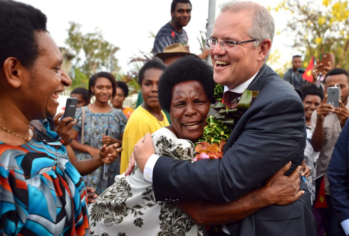 Australia's Prime Minister Scott Morrison is hugged by a woman as he greets locals at the opening of a new building at the University of Papua New Guinea after an Asia-Pacific Economic Cooperation forum in Port Moresby, Papua New Guinea on Nov. 18, 2018. (Mick Tsikas/Pool via Reuters)