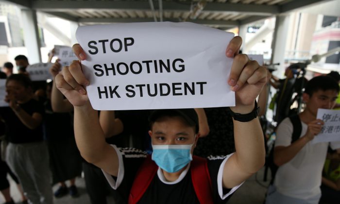 A protester holds a sign following a day of violence over an extradition bill that would allow people to be sent to mainland China for trial, in Hong Kong, on June 13, 2019. (Athit Perawongmetha/Reuters)