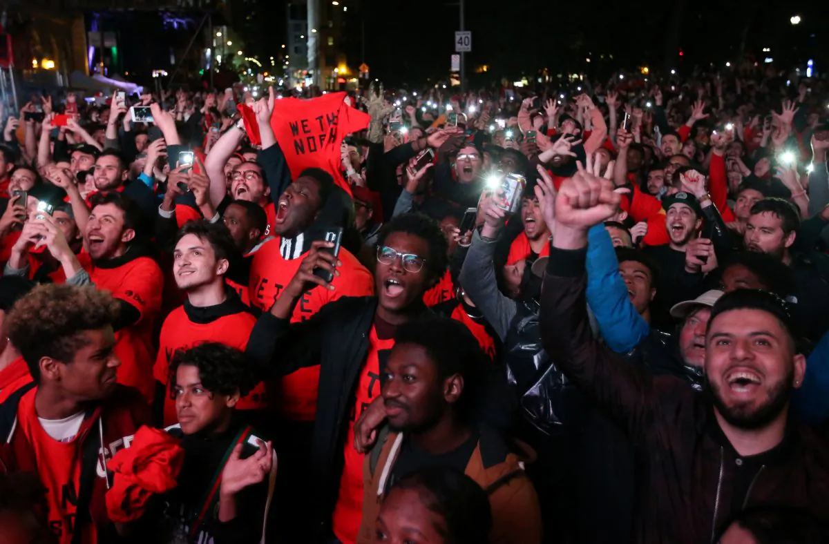 Fans celebrate their win in Game 6 of the NBA basketball Finals between the Toronto Raptors and the Golden State Warriors on a large screen in a fan zone in Montreal, Quebec, Canada, June 13, 2019. (Christinne Muschi/Reuters)