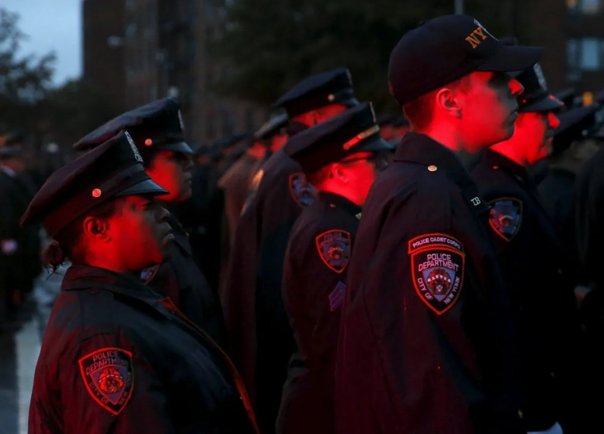 Police are lit by flashing lights as they stand in formation while the casket of slain New York City Police officer Randolph Holder is carried from the Greater Allen A.M.E. Cathedral of New York following his funeral service in the Queens borough of N.Y.C., on Oct. 28, 2015. (Shannon Stapleton/Reuters/File Photo)