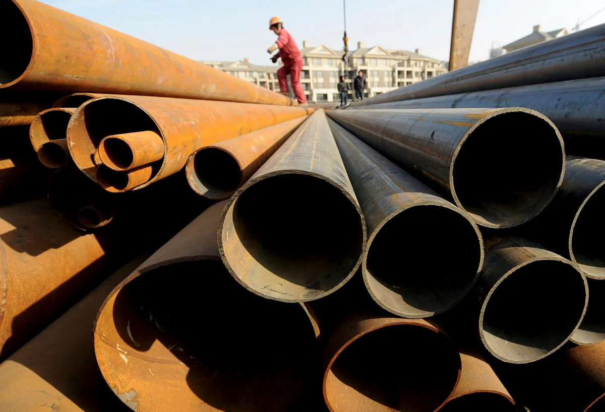 A laborer walks on steel pipes at a steel market in Hefei, Anhui Province, China on Dec. 31, 2009. (Reuters)