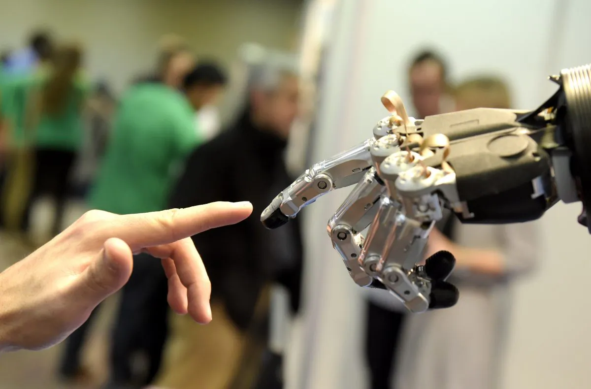 A man moves his finger toward an SVH (Servo Electric 5 Finger Gripping Hand) in Madrid, on Nov. 19, 2014. Gerard Julien/AFP/Getty Images