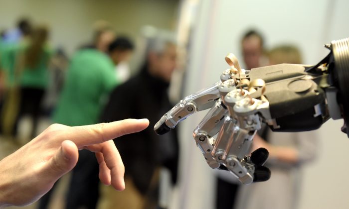 A man moves his finger toward an SVH (Servo Electric 5 Finger Gripping Hand) in Madrid, Spain, on Nov. 19, 2014. Gerard Julien/AFP/Getty Images