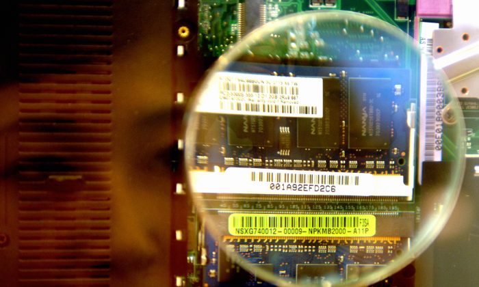 A woman looks through a magnifier to see a 2GB RAM from a notebook during the semi-tech show in Taipei 10 in May 2007.  (Sam Yeh/AFP/Getty Images)