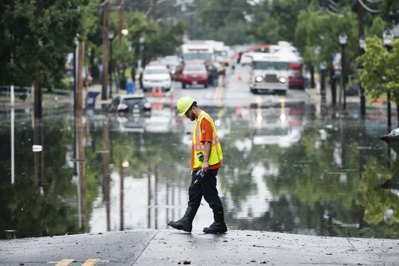 A utility worker walks the edge of the floodwaters submerging Broadway in Westville, N.J., on June 20, 2019. (Matt Rourke/Photo via AP)