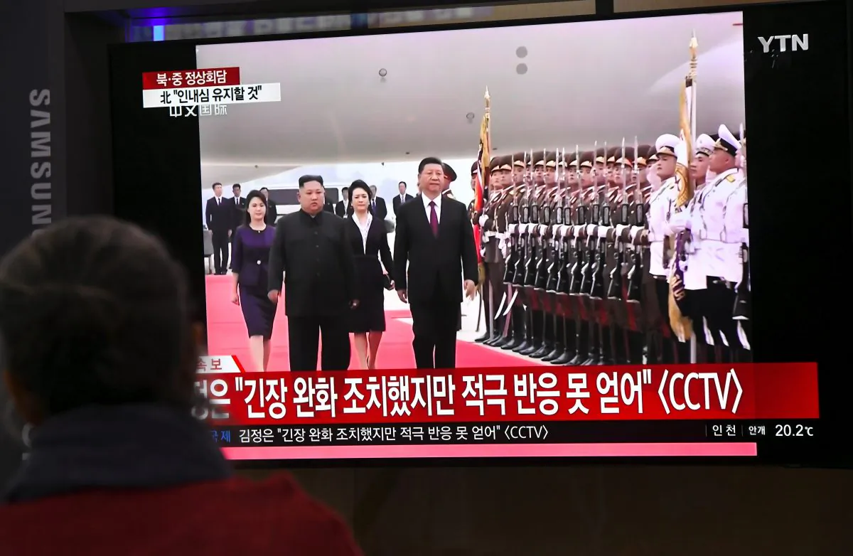 People watch television news screen showing North Korean leader Kim Jong Un welcoming Chinese President Xi Jinping at Pyongyang airport, at Seoul railway station in Seoul on June 20, 2019. (JUNG YEON-JE/AFP/Getty Images)