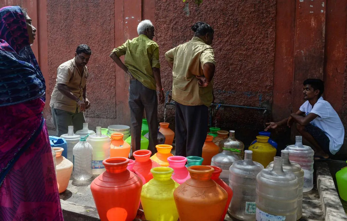 Indian residents stand around with plastic pots filled with drinking water at a distribution point in Chennai on June 19, 2019. (Arun Sankar/AFP/Getty Images)